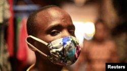 Eugene Amuri, a vendor at the Kimironko market, wears a handmade "kitenge" cloth mask as he attempts to protect against COVID-19, in Kigali, Rwanda, March 17, 2020.