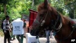 Electoral workers unload ballot boxes and other election paraphernalia to be transferred to horses and distribute them to polling stations in remote villages in Andongrejo, East Java, Indonesia, Feb. 13, 2024.