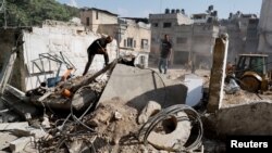 FILE - Palestinians stand at the site of the damaged office of United Nations Relief and Works Agency (UNRWA), following the Israeli raid, in Nour Shams camp, in Tulkarm, in the Israeli-occupied West Bank, Nov. 1, 2024.