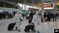 Penumpang di Bandara Paris Charles de Gaulle di Roissy, utara Paris, Prancis. Uni Eropa mengatakan, Jumat (26/11), blok itu sedang mempertimbangkan untuk menghentikan perjalanan udara dari wilayah selatan benua Afrika untuk menghindari penyebaran varian baru COVID-19.(Foto: AP)