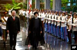 El presidente de Cuba, Miguel Díaz-Canel, a la izquierda, y el presidente de Irán, Ebrahim Raisi, pasan junto a la guardia de honor durante una visita de Estado a La Habana, Cuba, el jueves 15 de junio de 2023. (Foto AP/Ismael Francisco)