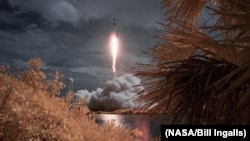 FILE - A SpaceX Falcon 9 rocket amd Crew Dragon spacecraft carrying NASA astronauts Robert Behnken and Douglas Hurley lifts off in this false color infrared exposure at the NASA’s Kennedy Space Center in Cape Canaveral, Florida, May 30, 2020. (NASA)