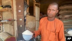 Isa Ahmed shows the granulated sugar he sells at his shop at a market in Abuja, Nigeria, Friday, Oct. 27, 2023. Sugar worldwide is trading at the highest prices since 2011. (AP Photo/Chinedu Asadu)