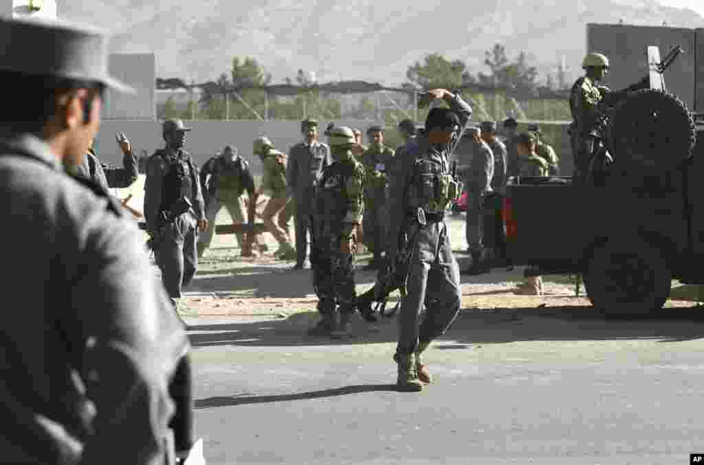 Afghan and foreign security forces inspect the site of a suicide attack at the deputy counter narcotic compound in Kabul, Afghanistan, July 22, 2014.&nbsp;
