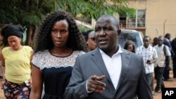 FILE - Wife Barbara Kyagulanyi of pop star and lawyer Asuman Basalirwa attempt to gain access to the military court trial of lawmaker, pop singer and prominent critic of Uganda's government Kyagulanyi Ssentamu, whose stage name is Bobi Wine, in Gulu, northern Uganda, Aug. 16, 2018. 