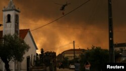 Helikopter pemadam kebakaran berusaha memadamkan api kebakaran lahan di Leiria, Portugal, 13 Juli 2022. (Foto: Rodrigo Antunes/Reuters)