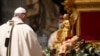 Pope Francis stands in front of a statue of Baby Jesus as he celebrates Mass on Christmas Eve at St. Peter's basilica at the Vatican Dec. 24, 2020. 
