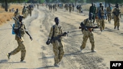 Sudan People's Liberation Army (SPLA) soldiers walk along a road in Mathiang near Bor, Jan. 31, 2014. 