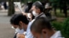Personas que usan máscaras protectoras para ayudar a frenar la propagación del coronavirus descansan en un parque el miércoles 14 de octubre de 2020 en Tokio.
