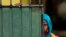 FILE - A Sri Lankan Muslim woman looks out on the street, in Aluthgama, town, 50 kilometers (31.25 miles) south of Colombo, Sri Lanka.