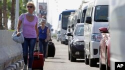 Tourists with their luggage walk towards the main entrance to the Sharm el-Sheikh airport in Egypt, Nov. 7, 2015.
