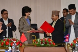 FILE - Nepal's Foreign Secretary Shankar Das Bairagi and China's Ambassador to Nepal Yu Hong, second from left, exchange documents during a signing ceremony relating to the One Belt One Road initiative in Kathmandu, May 12, 2017.