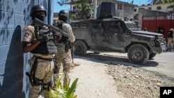 Police stand guard in front of the Police Academy during a funeral of three police officers killed in the line of duty in Port-au-Prince, Haiti, Jan. 31, 2023. On April 9, 2023 three more officers were killed in an ambush.