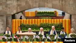 Líderes del G20, incluyendo al primer ministro de India, Narendra Modi, los presidentes de Brasil, Luiz Inácio Lula da Silva, y EEUU, Joe Biden, y el premier británico, Rishi Sunak, visitan el monumento a Mahatma Gandhi, el 10 de septiembre de 2023, en Nueva Delhi.