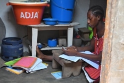 FILE - A schoolgirl receives online lessons in the district of Port Bouet in Abidjan, Ivory Coast, April 21, 2020.