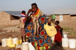 FILE - A Turkana woman washes her face at a water point within Kalobeyei Settlement outside the Kakuma refugee camp in Turkana county, northwest of Nairobi, Kenya, Feb. 1, 2018.