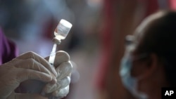 Seorang nakes mempersiapkan suntikan vaksin COVID-19 Sinovac dalam vaksinasi massal di Denpasar, Bali, 16 Maret 2021. (AP Photo/Firdia Lisnawati)