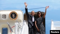 U.S. President Barack Obama and the First lady Michelle Obama wave from Air Force One upon their departure from Dar es Salaam, July 2, 2013. 