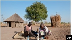 Feb. 8, 2010. Senwei Village, Terekeka Region, South Sudan. Guinea worm Eradication Program Village Volunteer Puru tends to her husband, Garbino's Guinea worm leg wound, at their home.