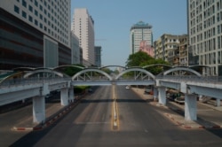 FILE - A car is seen on an empty street in downtown Yangon, Myanmar, March 24, 2021, during what anti-coup protesters called a 'silent strike.'