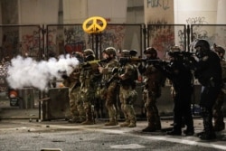 FILE - Federal agents use crowd control munitions to disperse Black Lives Matter demonstrators during a protest at the Mark O. Hatfield United States Courthouse, July 24, 2020, in Portland, Oregon.