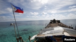 FILE - A Philippine flag flutters from BRP Sierra Madre, a dilapidated Philippine Navy ship that has been aground since 1999 and became a Philippine military detachment on the disputed Second Thomas Shoal in the South China Sea, March 29, 2014.