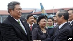 Indonesia's President Susilo Bambang Yudhoyono, left, shakes hands with Vietnamese minister Nguyen Van Chien, right, head of President's Office, as his wife Kristiani, center, stands by before their departure at the Noi Bai airport in Hanoi, 27 Oct 2010