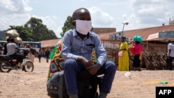 A boy sits on a bag at the old taxi park in Kampala, Uganda, on June 04, 2020, the first day of re-opening public transport.