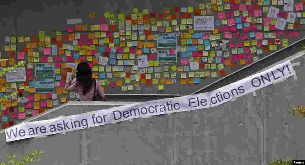 A woman looks at notes left by pro-democracy protesters on a footbridge in Hong Kong, Oct. 2, 2014.