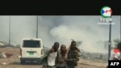 Un homme blessé assisté par des militaires à Bata, en Guinée équatoriale le le 7 mars 2021. (Photo by - / TVGE / AFP) 