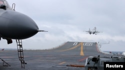 FILE - J-15 fighters from China's Liaoning aircraft carrier conduct a drill in an area of South China Sea, Jan. 2, 2017.