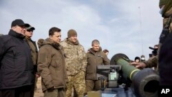 El presidente ucraniano Volodymyr Zelenskyy, centro izquierda, muestra armas antitanque NLAW durante un simulacro militar en las afueras de la ciudad de Rivne, en el norte de Ucrania, el miércoles 16 de febrero de 2022. (Oficina de Prensa Presidencial de Ucrania vía AP)