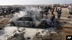 A destroyed car smolders after a bombing in Karbala, 80 kilometers (50 miles) south of Baghdad, Iraq, 20 Jan 2011