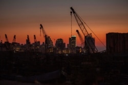 Rows of damaged cranes stand at the site of the Aug. 4 deadly blast in the port of Beirut that killed scores and wounded thousands as the sun sets over the capital Beirut, Lebanon, Aug. 25, 2020.