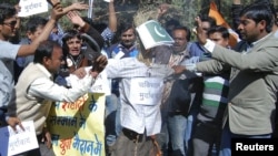 Activists of the youth wing of India's ruling Congress party shout slogans as they beat and burn an effigy depicting Pakistan during a protest in the central Indian city of Bhopal, January 9, 2013.