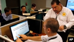 FILE - Puerto Rico Health Department workers monitor social media for Zika-related issues at the department's headquarters in San Juan. 