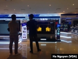 FILE - Shoppers check out smart TVs in Hanoi. Analysts recommend Vietnam retrain workers for the technology sector to meet the demand for new skills.