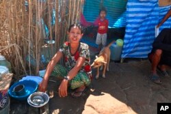 FILE - Displaced people from Myanmar live under a makeshift tent along the Thai side of the Moei River in Mae Sot, Thailand, Feb. 7, 2022.