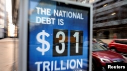 Mobil-mobil melintas di sebuah papan iklan yang menunjukkan angka utang Amerika Serikat, di Washington, 20 Januari 2023. (Foto: Amanda Andrade-Rhoades/Reuters)