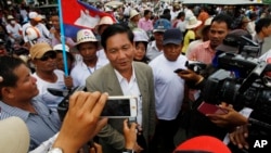 FILE - Thach Setha, center, a prominent vice president of the country's main opposition, Candlelight Party, talks to media members near the Vietnam Embassy in Phnom Penh, Cambodia, on Aug. 14, 2014.