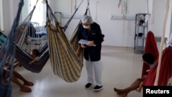 A nurse talks to a mother whose son is being treated for malnutrition at the special ward for indigenous people of the Santo Antonio Children's Hospital, in Boa Vista, Brazil, Jan. 27, 2023.