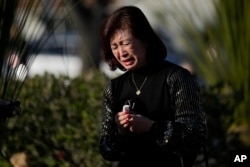 Judy Man cries near a memorial outside Monterey Park City Hall, blocks from the Star Ballroom Dance Studio on Tuesday, Jan. 24, 2023, in Monterey Park, California.