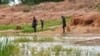 FILE - Children in the town of Terekeka, South Sudan, draw water, Oct. 4, 2017, from a stagnant pond that was once infected with Guinea worm when the town was endemic. 