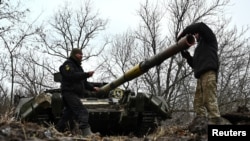 Ukrainian service members check a tank barrel during offensive and assault drills, amid Russia's attack on Ukraine, in Zaporizhzhia Region, Ukraine, Jan. 23, 2023. 
