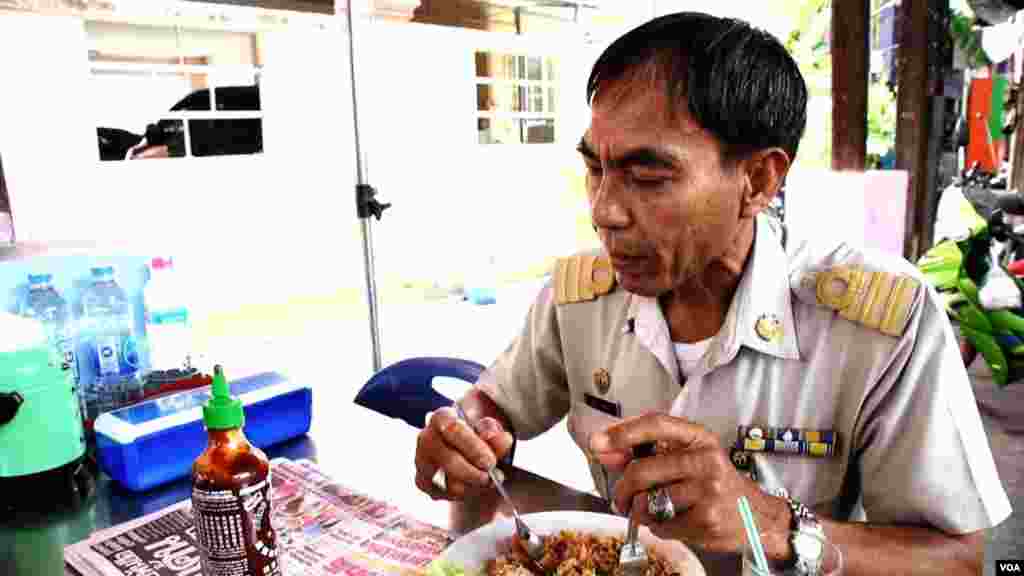 Si Racha municipal government officer and art director Booncherd Nilsonthi glances at a bottle of American-made "Sriracha sauce." (Z. Aung/VOA)