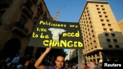 A protester holds up a placard during a rally against the extension of the current parliament's mandate, in Beirut, June 20, 2013.