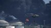 Helikopter pemadam kebakaran menjatuhkan air di Matanzas Supertanker Base untuk memadamkan api akibat disambar petir sehari sebelumnya, di Matanzas, Kuba, Sabtu, 6 Agustus 2021. (AP/Ramon Espinosa)