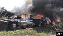 This handout picture taken and released by the Ukrainian Emergency Service on Aug. 8, 2022, shows firefighters working to put out a fire after a missile was shot down and landed on civilian infrastructure in Uman district. 