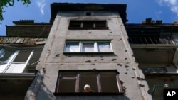 Ida Svystunova, de 89 años, observa la habitación dañada contigua a su apartamento por un ataque con cohetes en mayo en Sloviansk, región de Donetsk, este de Ucrania, el 7 de agosto de 2022.