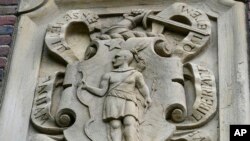 FILE - Relief panel on Johnston Gate, Harvard University's first and largest gate heading to the campus, in Cambridge, Mass., May 23, 2021.